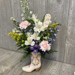 Mixed flowers arranged in a decorative cowboy boot vase