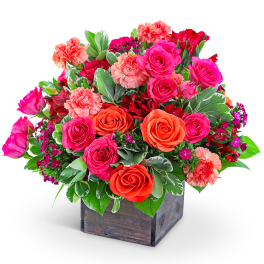 Mixed bouquet of pink and orange roses with carnations in a wooden box