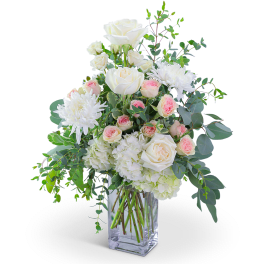 White roses and chrysanthemums in a clear glass vase