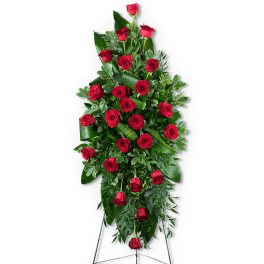 Tall standing spray of red roses and greenery on an easel