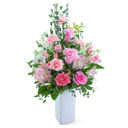 Pink and white floral arrangement in a tall white vase
