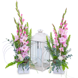 Pink gladiolus arrangements flanking a white lantern centerpiece