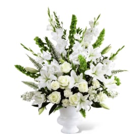 White lilies and roses arranged in a white vase