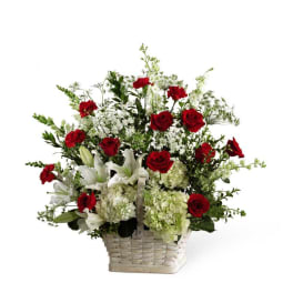 Basket arrangement of red roses and white lilies with white filler flowers