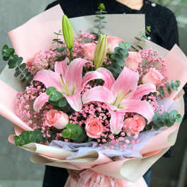 Pink lily and rose bouquet wrapped in pastel paper