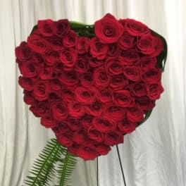 Heart-shaped arrangement of red roses on a stand