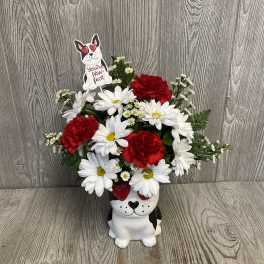 Red carnations and white daisies in a dog-shaped vase with a paw-fect sign