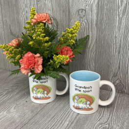 Pink carnations in a mug beside a matching printed mug