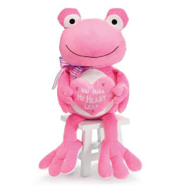 Pink plush frog holding a heart, seated on a small white stool