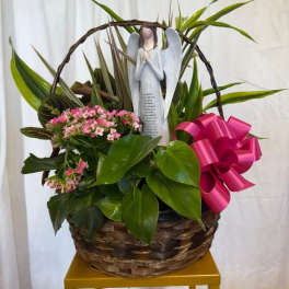 Basket of pink flowers with an angel figurine and bright ribbon