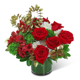 Red roses and white flowers in a glass vase with gold foliage