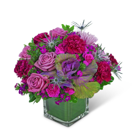 Pink and purple floral arrangement in a clear square vase
