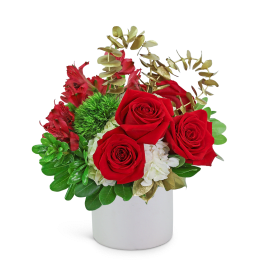 Red roses and white flowers in a white vase with gold foliage