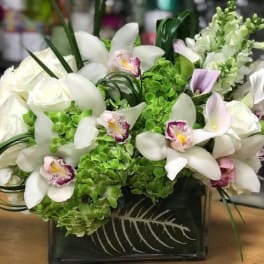 White orchids and roses in a black square vase