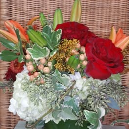 Red roses and lilies arranged in a square glass vase