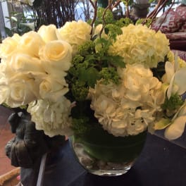 White roses and hydrangeas arranged in a glass vase