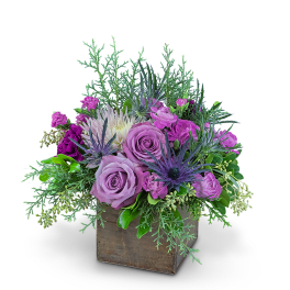 Purple roses and mixed blooms in a wooden box