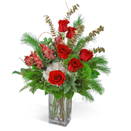 Red roses and white blooms in a clear glass vase with greenery