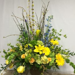 Tall mixed flower arrangement with yellow lilies and gerbera daisies in a vase