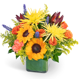 Sunflowers and orange roses in a square glass vase