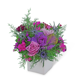 Pink and purple mixed flower arrangement in a white cube vase