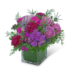 Purple and pink bouquet in a clear square vase