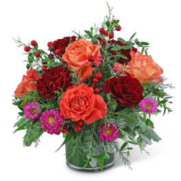 Bouquet of orange and red roses with purple daisies in a glass vase