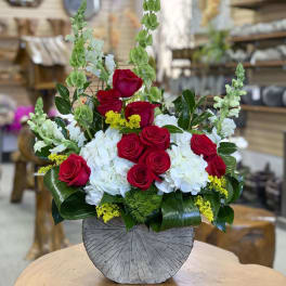 Red roses and white hydrangeas in a round gray vase