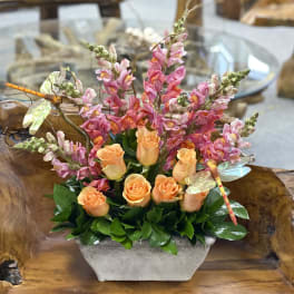 Orange roses and pink snapdragons in a rectangular planter