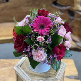 Bouquet of pink and red flowers in a white vase