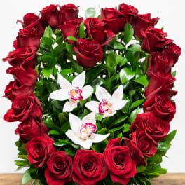 Red roses and white orchids in a square gray container