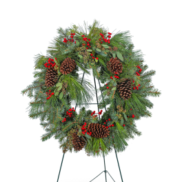 Evergreen wreath with pinecones and red berries on a stand
