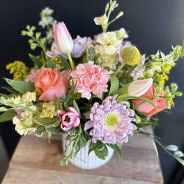 Pastel bouquet in a white ribbed vase with roses, tulips, and chrysanthemums