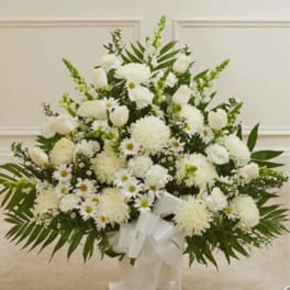 White floral standing spray with daisies, carnations, and roses