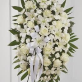 White floral standing spray with ribbon on an easel
