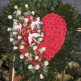 Heart-shaped floral tribute with red carnations and white roses