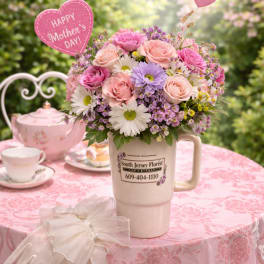 Pink and lavender flower arrangement in a mug with Mother's Day heart picks
