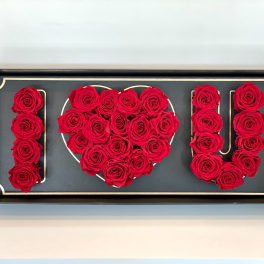 Red roses arranged to spell "I ♥ U" in a framed display