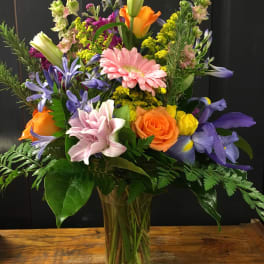 Mixed bouquet of colorful flowers in a clear glass vase