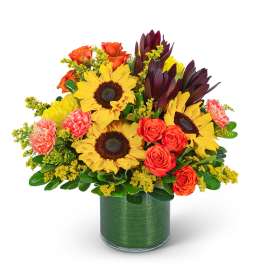 Bouquet of sunflowers, orange roses, and carnations in a green vase
