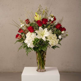 Red roses and white lilies arranged in a clear glass vase