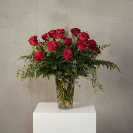 Red roses arranged in a clear glass vase
