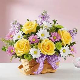 Basket of yellow roses and daisies with a purple ribbon