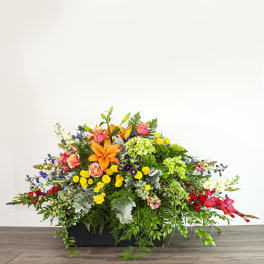Large mixed floral arrangement in a black rectangular container