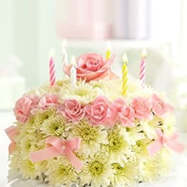 Pink roses and white daisies arranged as a birthday cake with candles