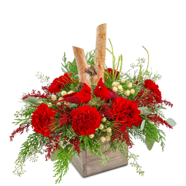 Red carnations with berries and greenery in a wooden box, topped with two cardinal figurines