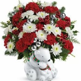 Red and white floral arrangement with a white teddy bear base