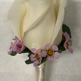 Cream rose boutonniere with small purple accent flowers