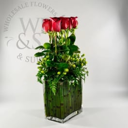 Tall arrangement of red roses in a clear glass vase