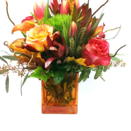 Mixed bouquet of roses and tulips in an orange glass vase